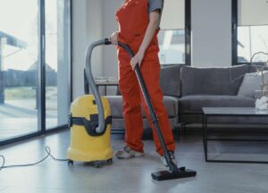  Woman cleaning corporate offices with yellow vacuum cleaner