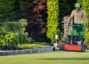 Man with a lawn mower cutting his lawn