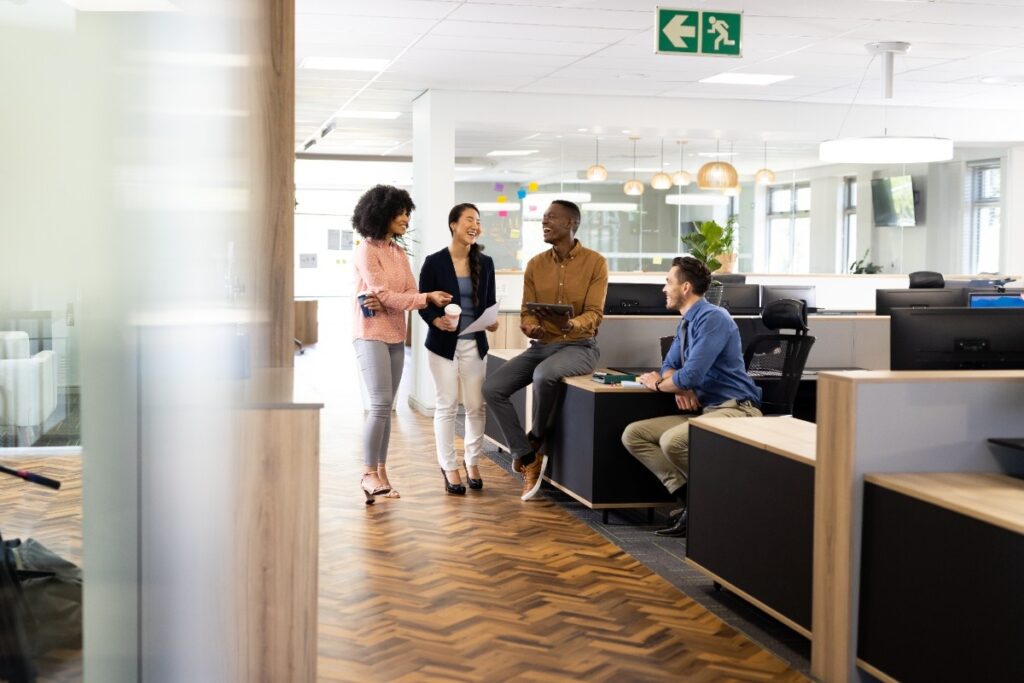 Diverse businesspeople in office talking and laughing