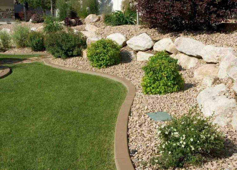 landscaping with edged pavers, pebbles and trimmed shrub trees