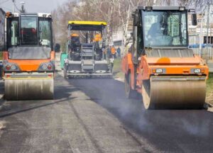 Two road rollers compacting recently laid asphalt