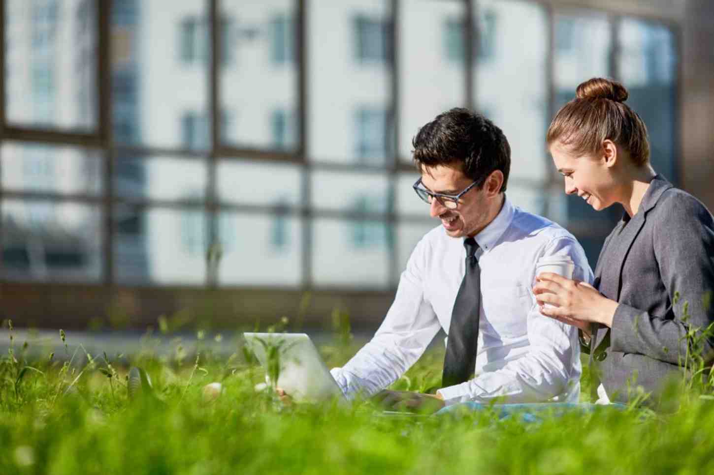 A formally dressed man and woman looking at laptop