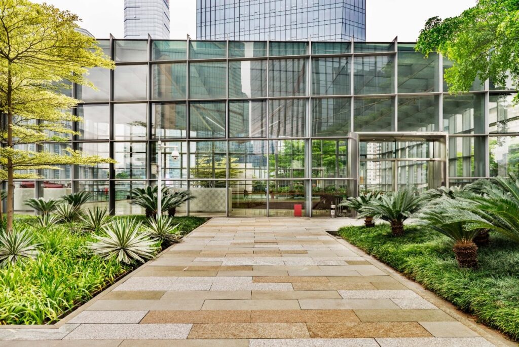 beautiful office entrance with stone tiles and green vegetation leading to entrance