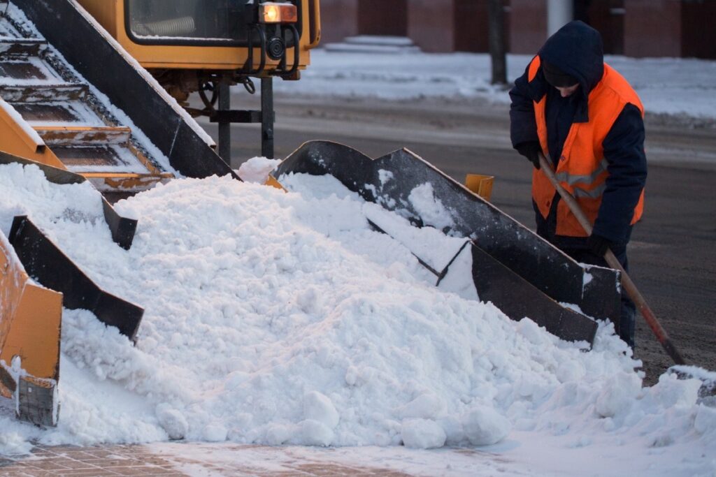 workers-sweep-snow-from-road-in-winter-cleaning