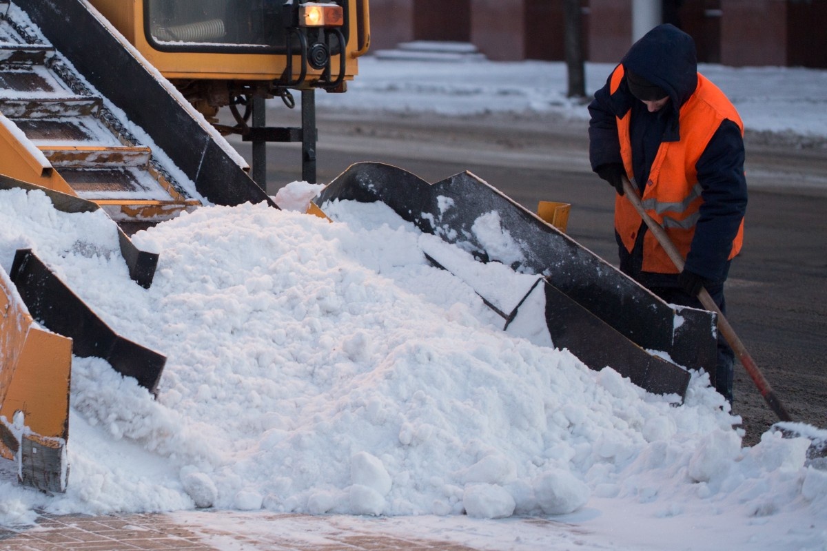workers-sweep-snow-from-road-in-winter-cleaning