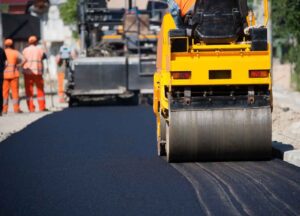 Machine compacting recently laid asphalt