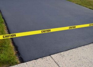 recently asphalt sealcoating that was laid with a yellow caution ribbon above it