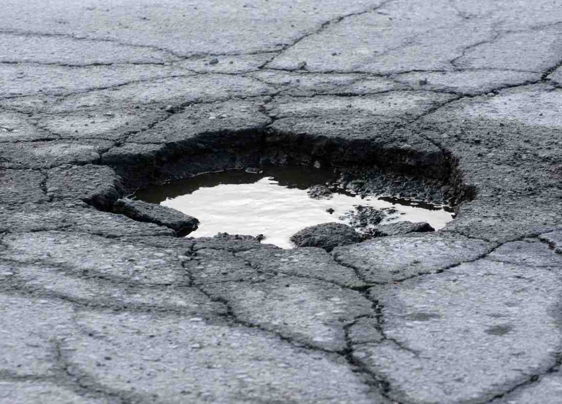 A deep pothole is asphalt lot