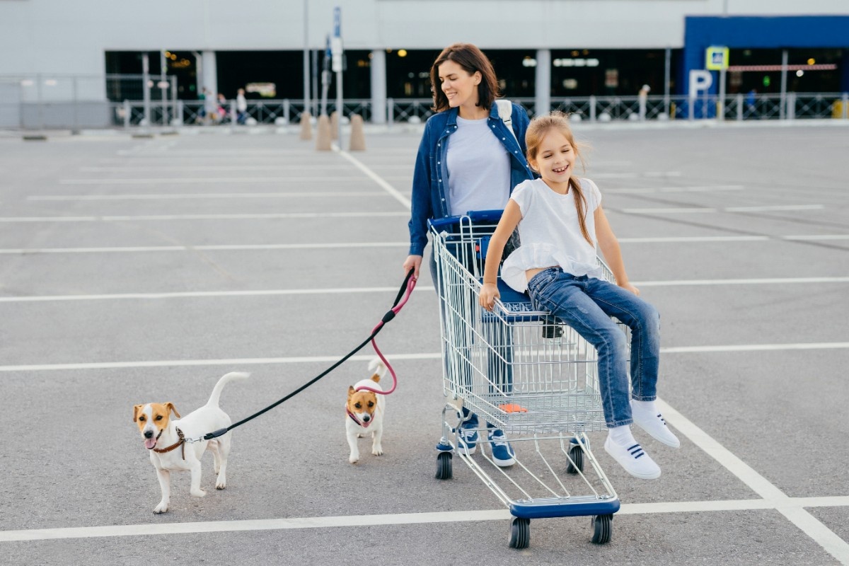 happy-mother-and-her-little-daughter-walk-with-dog