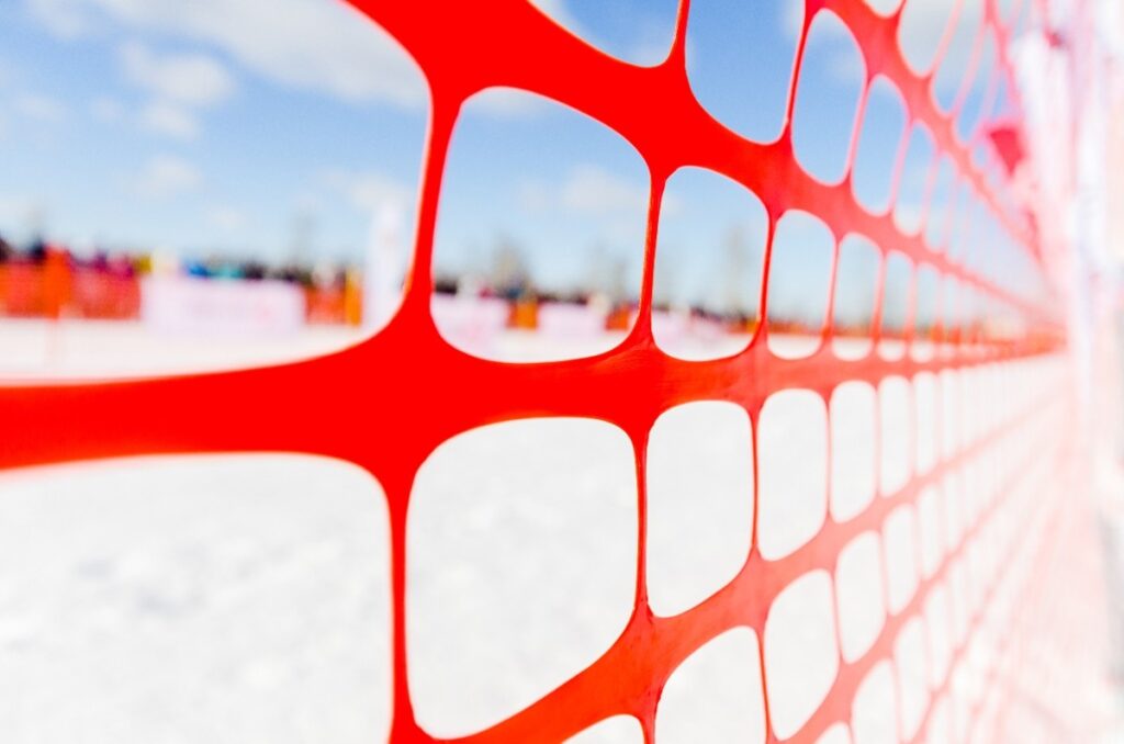 Close up of red snow fence is a snow covered field