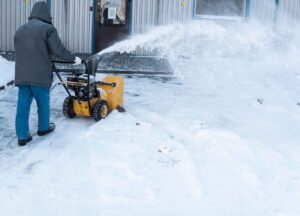 man clearing snow with snow removal machine