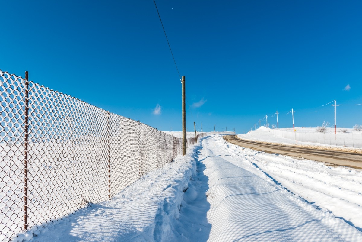 Snow fence along the road with blue clear skies