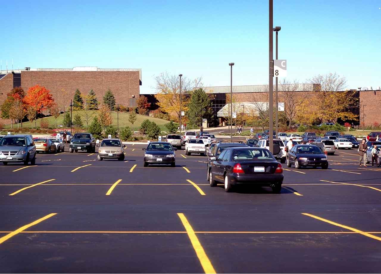commercial parking lot with yellow lines and cars parked all over
