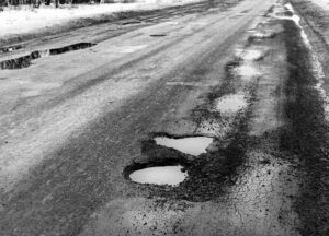 asphalt with potholes with water in them
