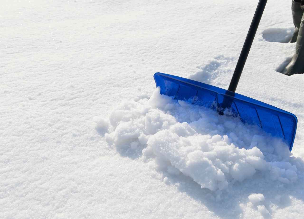 someone with a snow shovel, clearing snow