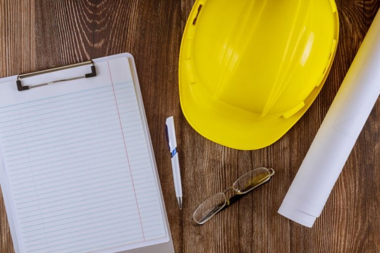 Yellow helmet checklist and pen on a wooden desk