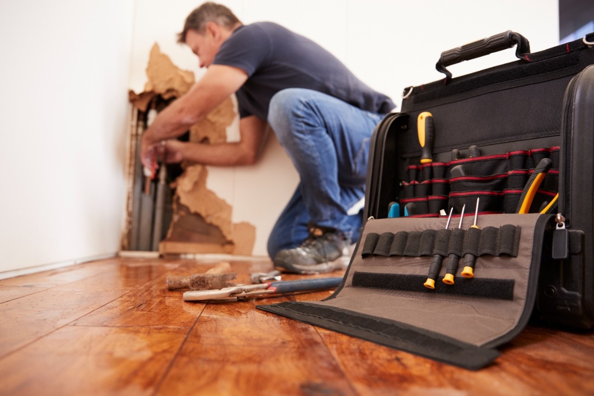 middle-aged-man-repairing-burst-pipe-plumbing