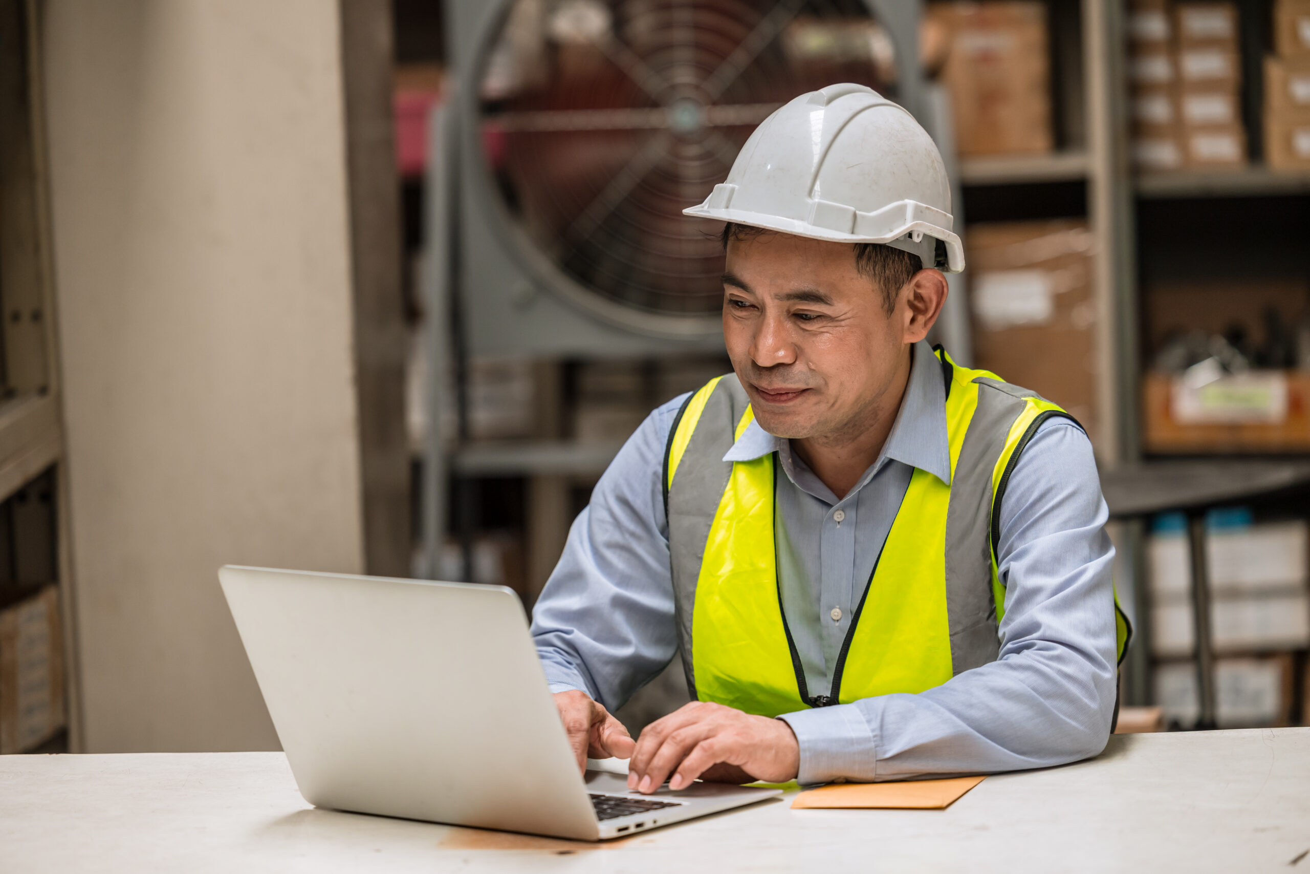 senior adult supervisor smiling worker on laptop