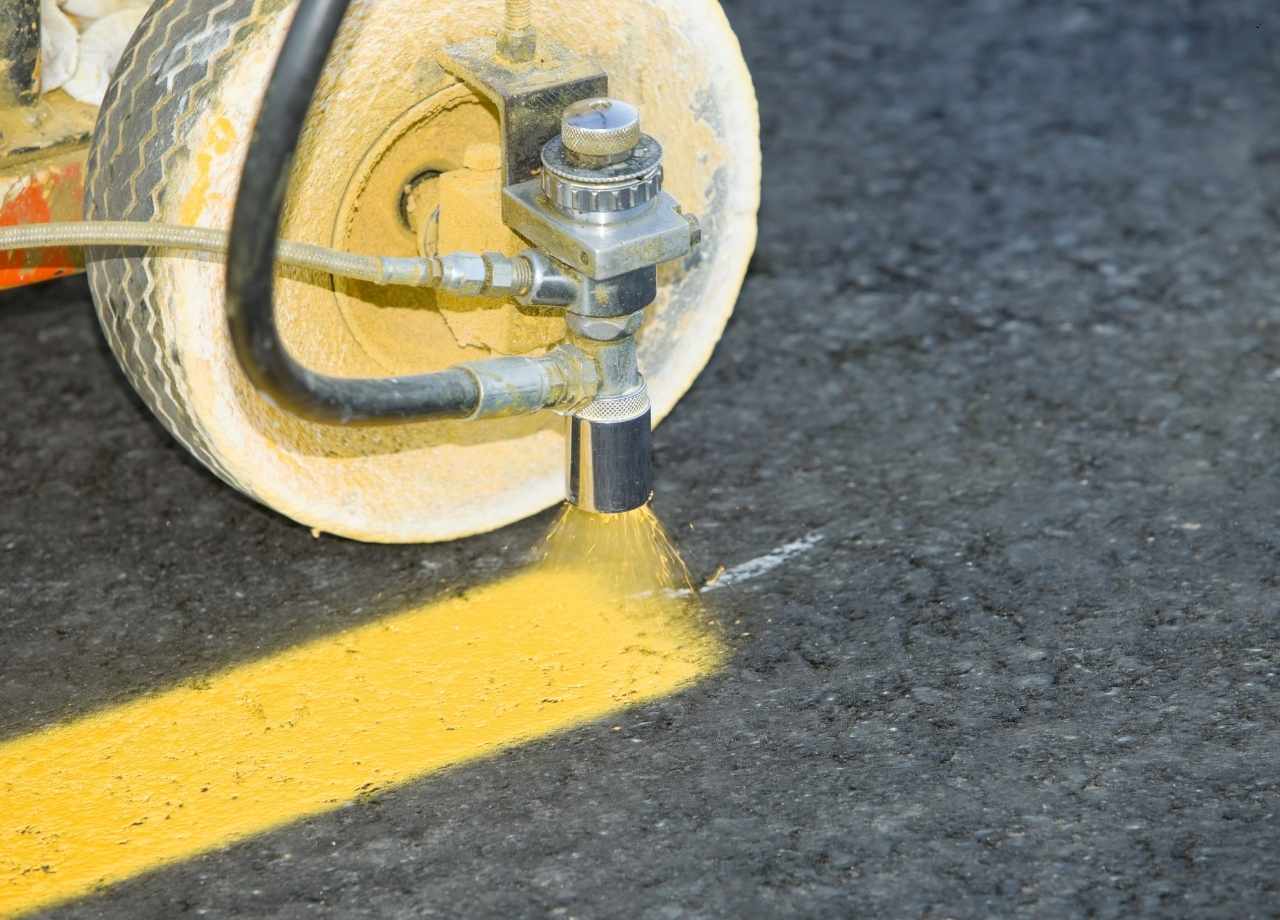 A machine marking yellow lines on a parking lot