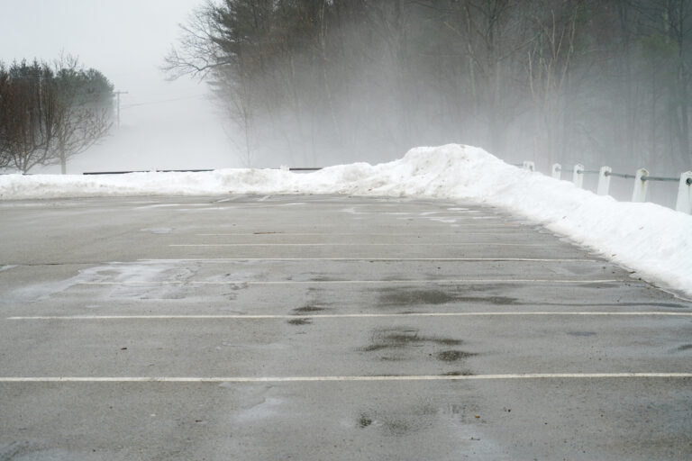 empty parking lot with fog in winter morning with snow removal