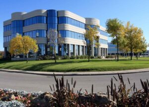 A 3-story office is surrounded by green landscaping, flowers, and trees, making a strong first impression.