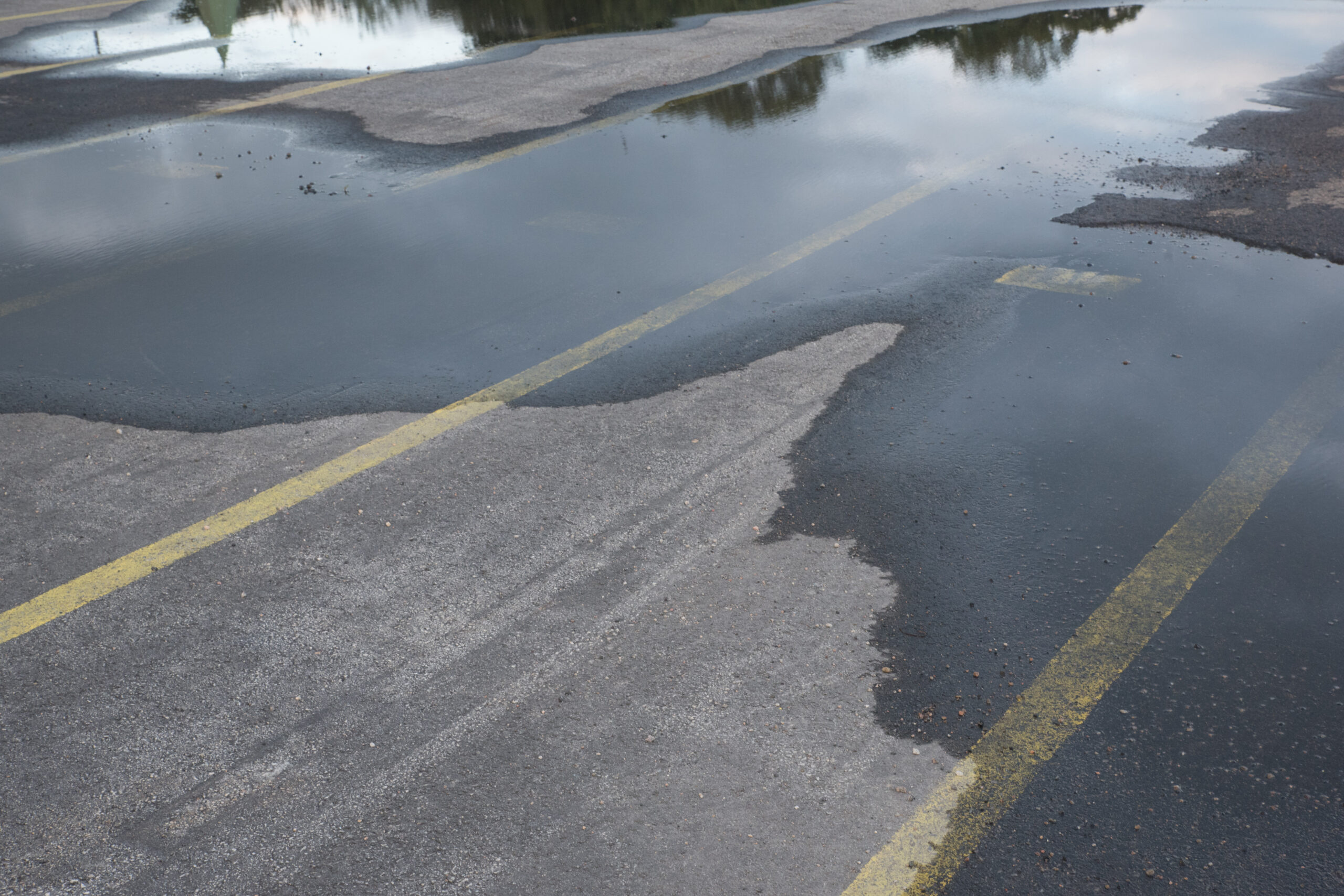 how water damages asphalt parking lot wet after rain