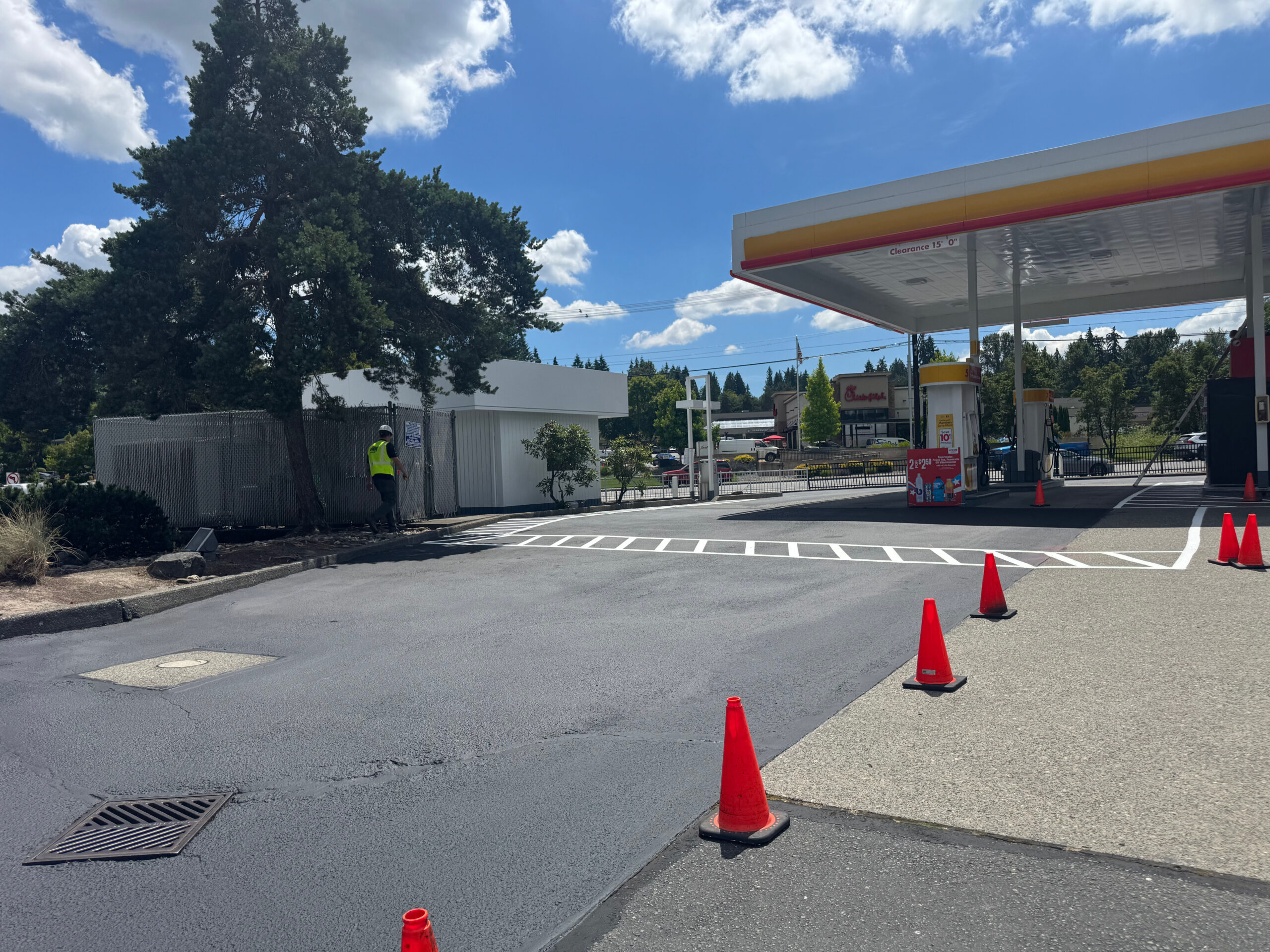 A freshly sealcoated and striped parking lot at a gas station, showing the commercial parking lot life cycle.